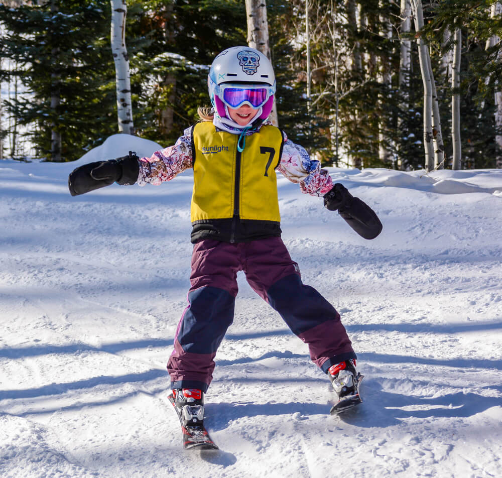 Child smiling while doing a ski lesson in colorado
